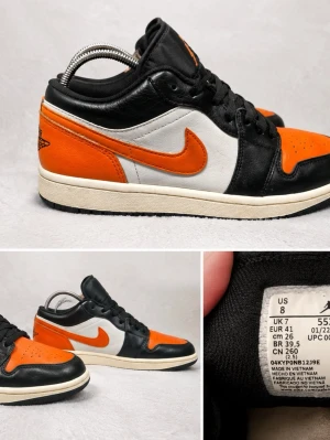 Nike Air Jordan 1 Low svart och orange special edition  - Säljer ett par Air Jordan 1 Low sneakers i svart och orange läder med svarta sulor som hör till skorna. Skorna har klassisk Jordan-logga på hälen och Jumpman-logga på plösen. Snygg kontrast mellan det svarta och orangea, perfekta för dig som gillar streetwear och sportig stil. (Kommer med kartong.)