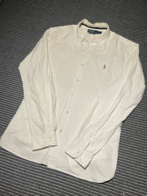 Vit Ralph Lauren Skjorta - Säljer denna vita skjorta från Ralph Lauren i storlek L Slim fit. Skjortan är i toppskick utan skavanker! | Nypris: ca: 1600kr | Tveka inte på att höra av dig vid funderingar!🤩