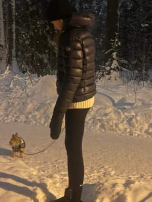 Mörkblå colmar dunjacka - Snygg och varm mörkblå dunjacka från colmar  med glansig finish och klassisk puffer-design. Perfekt för kalla vinterdagar. Ikonisk logga på ärmen och dragkedja framtill.