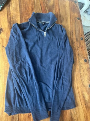Mörkblå stickad tröja Jack & Jones - Mörkblå stickad quarter zip tröja från Jack & Jones. Säljer nu för den är för liten för mig. Passar bra till ett par jeans nu till hösten. Riktigt snygg och riktigt bra skick.