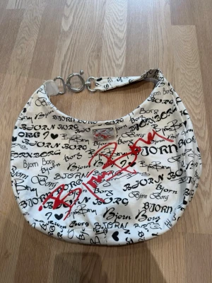 Väska från Björn Borg - Rymlig väska i fint skick, använd fåtal gånger. Axelväska brettband med silver detaljer. Röd och svart logga. Perfekt som vardags- eller weekendväska.✨