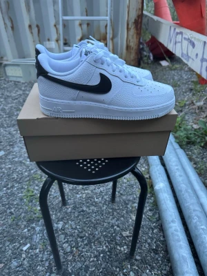 Nike Air Force 1 Sneakers Vit/Svart strl 42 - Helt nya Nike Air Force 1 Sneakers Vit/Svart strl 42. Skorna har inte blivit använda eller testade   Original kartong saknas. Därav pris. Pris kan diskuteras.  Nypris hos Nike 1400 kr