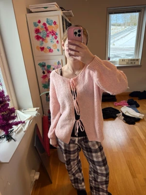 Ljusrosa fluffig kofta med knytband - Supermysig ljusrosa kofta med tre knytband framtill. Koftan har en lös passform, ballongärmar och ribbade muddar. Perfekt över ett linne. Finns tyvärr ingen prislapp men skulle tro S/M 