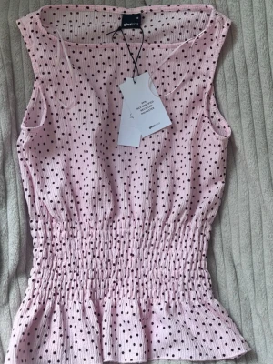 Prickig topp från gina - fin rosa topp från gina i luftigt material, går in i midjan och ut längst ner som ger en fin form. Aldrig använd då den är lite för stor för mig. Storlek xs men skulle säga att den passar s också. 