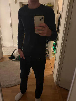 Dressman Mörkblå stickad tröja - En stilren dressman mörkblå stickad tröja med rund halsringning och långa ärmar. 