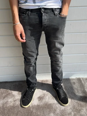 Jack & jones jeans mörkgrå - Tjena! Snygga mörkgrå jeans från jack&jones! Som referens är modellen på bilden 183cm och väger 68kg. Passform: Slim/glenn i storleken W32/L34. 70% bomull, 28%polyester, 2% elastan. Hör gärna av dig om du har några frågor. Mvh