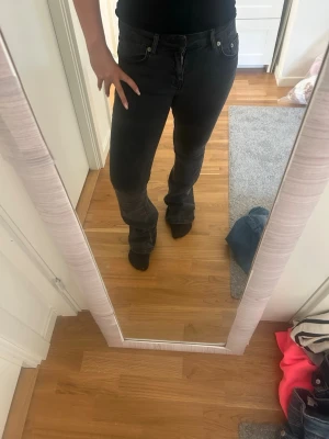 Svarta bootcut jeans - Säljer ett par svarta bootcut jeans med klassisk femficksdesign och normal midja. Jeansen har en snygg tvätt och är tillverkade i ett stretchigt material som sitter bekvämt. Perfekta för dig som gillar en avslappnad men ändå trendig look. S/short 