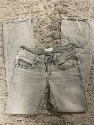 Ljusgrå raka jeans från Perfect Jeans - Säljer ett par ljusgrå jeans från Perfect Jeans i storlek 36. Jeansen har raka ben, klassisk femficksmodell och råa kanter vid bensluten för en trendig look. Perfekta till sneakers eller boots och passar till många olika stilar.