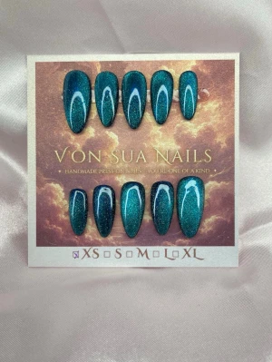 Nerissa (XS);Medium Almond - Handgjorda press-on nails i Medium Almond med djup teal cat eye-effekt och ljusa handmålade detaljer. Det magnetiska skimret skiftar vackert i olika ljus och ger designen extra djup. ✨  Storlek: XS Form: Medium Almond 10 handgjorda naglar Prep-kit medföljer.