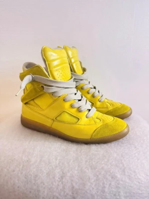 Maison Margiela - Säljer mina Maison Martin Margiela paneled high top sneakers från vår/sommarkollektionen 2008 (ss08). Även året dom hade 20-årsjubileum.  Den gula färgen producerades endast under en specifik säsong och betraktas som en av de mest eftertraktade originalfärgerna, därav ett extremt sällsynt samlarobjekt i riktigt bra skick.  •Storlek 40 men passar 41 •Box medföljer    Tveka inte om du är intresserad eller har några frågor! 