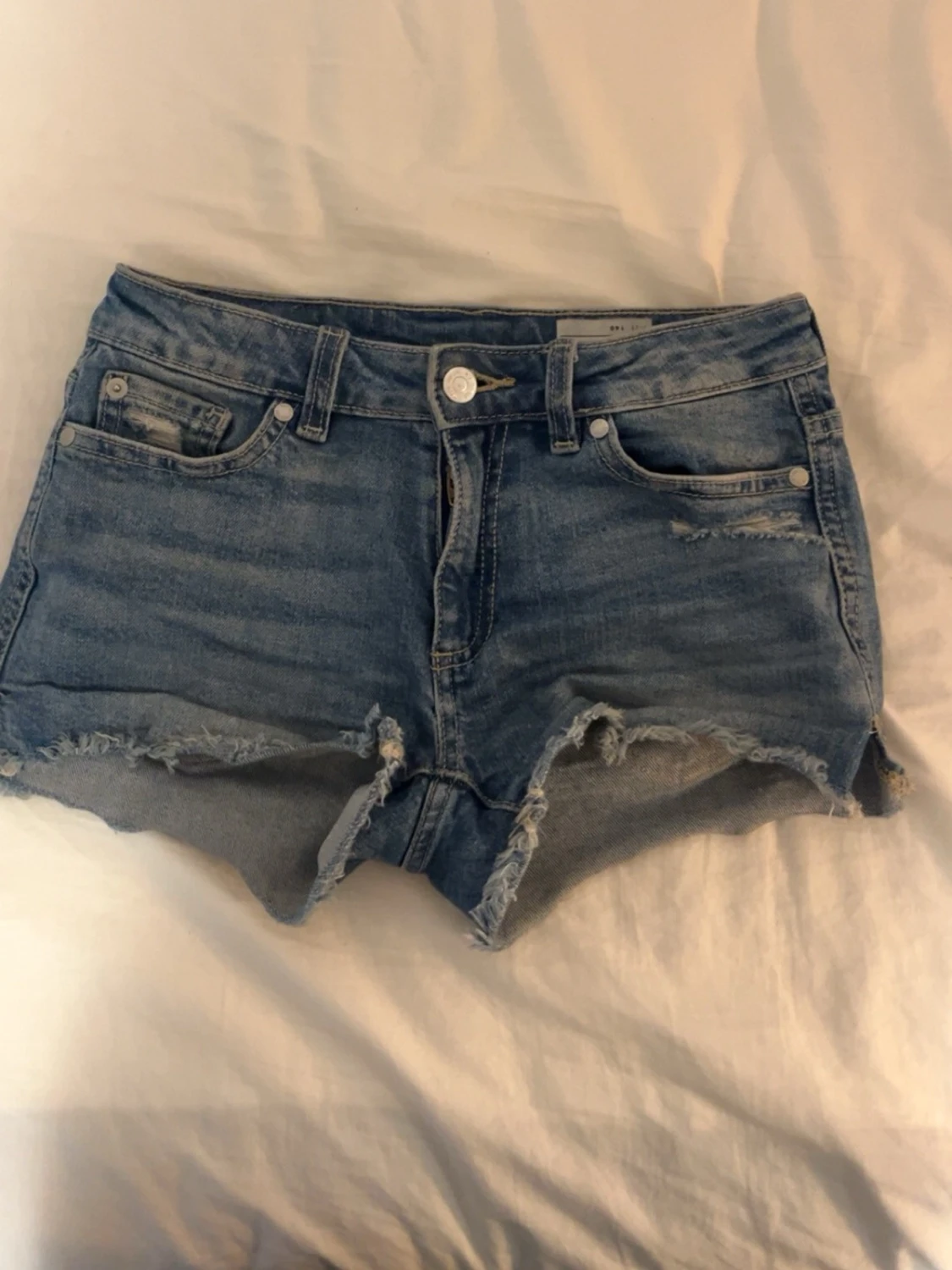Blå jeansshorts med rosa detalj på baksidan