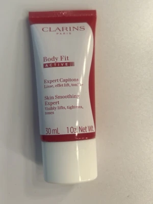 Clarins Body Fit Active 30 ml - Clarins Body Fit Active är en hudutjämnande expertkräm i en smidig tub på 30 ml. Krämen är röd och vit, och hjälper till att synligt lyfta, strama upp och tona huden. Perfekt för dig som vill ha en effektiv hudvårdsprodukt med fräsch doft.