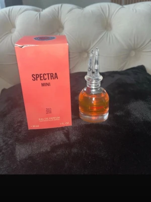 Spectra Mini Eau de Parfum 30 ml - Unik parfymflaska med orangefärgad vätska och dekorativt genomskinligt lock. Spectra Mini No 238 kommer i en snygg rosa kartong och innehåller 30 ml eau de parfum. Flaskan har en rund form och känns lyxig och modern.