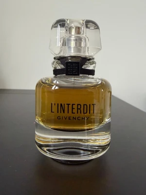 L'Interdit parfym från Givenchy - Givenchy L'Interdit (Eau de Parfum, 35 ml) är en elegant, intensiv och chic doft. Den öppnar med fräsch apelsinblomma, päron och bergamott, har ett fylligt hjärta av jasmin och tuberos samt landar i en mörk, lyxig bas av patchouli, vetiver och vanilj. Flaskan är på 35 ml och endast några enstaka spray har använts.