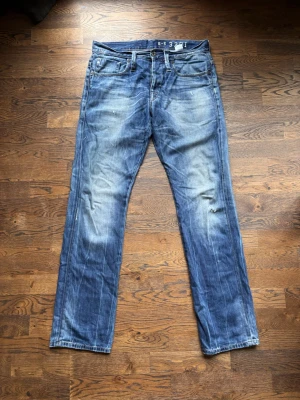 Blåa G-Star jeans  - Tjenare, säljer nu ett par feta G-Star jeans i färgen blå de har slitningar o en go wash. Längden är 113 cm lång och midjan är 44 cm lång