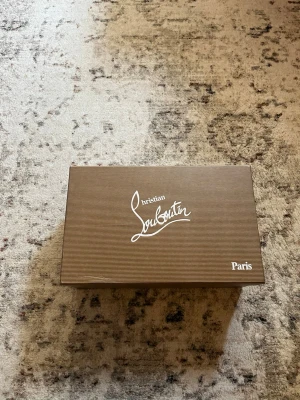 Svarta sneakers från Christian Louboutin - Snygga svarta sneakers från Christian Louboutin med coola nitar på tån och sidorna. Skorna är i läder och har klassisk snörning. Perfekta för dig som vill sticka ut med en exklusiv och edgy stil.