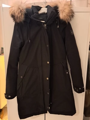 Svart parkas med fuskpälsluva - Jättefin jacka Stl 36  En liten söm (ca 2 cm) har gått upp längst ner på ena fickan. Se nästsista bilden för markering.  Fickan går dock fortfarande fint att använda. (Äkta päls)  I övrigt inget att anmärka på.   Obs säljs utan luddet på luvan eftersom det strider mot reglerna.  Nypris ca 3600 kr. 