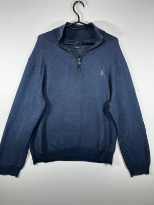 Polo Ralph Lauren Quarter Zip Tröja – Blå – XL – Pima Cotton - Klassisk Polo Ralph Lauren quarter zip i blå färg, tillverkad i 100% Pima-bomull. Broderad Pony-logga på bröstet och half/quarter zip-krage.  • Storlek: XL • Material: 100% Pima Cotton • Färg: Blå/navy • Broderad Ralph Lauren Pony • Quarter zip • Fint begagnat skick  Stilren modell som passar perfekt till både vardag och mer uppklätt.  📏 Mått kan skickas vid önskemål 📦 Skickas snabbt och välpaketerat