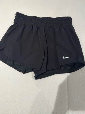Tränings shorts  - Svarta tränings shorts från Nike med inbyggda tighta shorts på insidan . Aldrig använd 