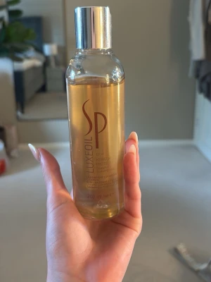 SP Luxe Oil hårolja 200 ml - SP Luxe Oil är en lyxig hårolja i en genomskinlig plastflaska med silverfärgat lock. Oljan är gyllene och flaskan rymmer 200 ml. Perfekt för att ge håret glans och skydd utan att tynga ner. Säljer denna då jag inte använder den och har använt den väldigt lite som man ser