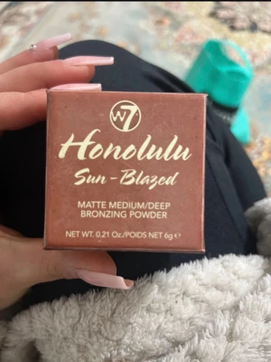 W7 Honolulu Sun-Blazed Bronzer - Matte bronzer i färgen medium/deep från W7, Honolulu Sun-Blazed. Kommer i en kompakt, fyrkantig förpackning i brun nyans med guldtext. Innehåller 6g bronzing powder som ger en solkysst look med matt finish.