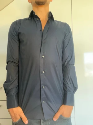 Mörkblå skjorta från Eton - Mörkblå skjorta från Eton. Strl 38/ S. Inga defekter. Nypris runt 1200-2000kr. Modellen är 178 cm och väger 77 kg. Hör gärna av dig vid frågor!