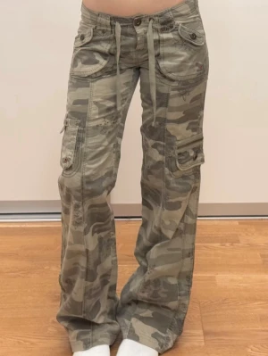 lowrise camo pants - super snygga camouflage mönstrade militärbyxor med utsvängda ben och låg midja storlek på lappen är 32 de passar bra för xs/s midja 36 cm men passar även mindre dă det finns band som kan knytas och göra midjan mindre innerben 77