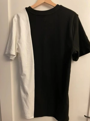 Svartvit boohooMAN T-shirt (Strl. S Tall) - Snygg blockfärgad t-shirt från boohooMAN i svart och vitt! Modellen är från deras ”TALL”-kollektion i storlek S, vilket gör den perfekt lång i passformen. Väldigt skönt och stretchigt material (91% polyester, 9% elastan). Använd men i jättefint skick! Perfekt till streetwear-outfits.