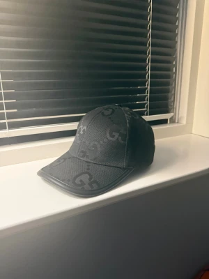 Svart keps - Snygg svart keps. Justerbar baktill för perfekt passform och tillverkad i ett slitstarkt tygmaterial. Perfekt accessoar för dig som vill ha en stilren och exklusiv look.