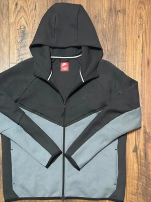 Nike Tech Fleece Windrunner Hoodie - Säljer en riktigt clean Nike Tech fleece i svart/grå färg – passar perfekt till vardag eller chill outfits 💯 ✅ Storlek: XL ✅ Skick: Mycket bra ✅ Äkta vara 🚚 Skickas inom 24h 💸 Pris kan diskuteras vid snabb affär Skriv vid frågor eller fler bilder! 📩 Först till kvarn 👀