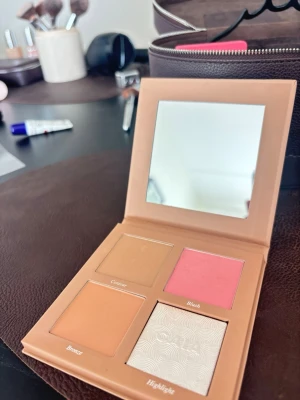 Caia Sassy Palett - Säljer en fyrdelad sminkpalett med spegel. Paletten innehåller en rosa rouge, en ljusbrun contour, en varm bronzer och en skimrig highlighter. Från Caia. Endast öppnad. Säljer ej för under 200kr då den är helt ny, så lägg ej några bud under 200