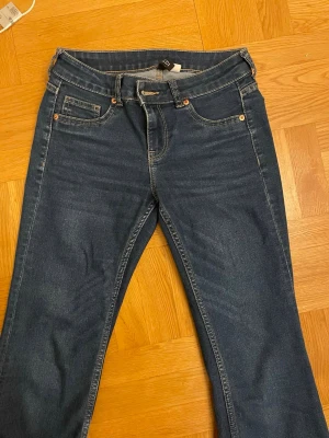 Mörkblå utsvängda jeans med fem fickor - Snygga mörkblå jeans med klassisk femficksmodell och utsvängda ben. Jeansen är lågmidjade och tillverkade i denim med en tidlös look som passar till det mesta.