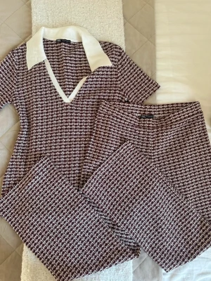 Mönstrat set från ZARA med krage - Ett snyggt tvådelat set från ZARA med kortärmad topp och matchande byxor. Materialet är stickat och ger en retrovibe.