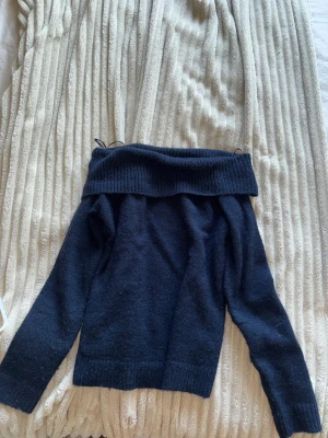 Mörkblå off shoulder stickad tröja - Snygg mörkblå stickad tröja med bred off shoulder-krage och långa ärmar. Tröjan har ribbstickade muddar vid ärmslut och nederkant. Perfekt för dig som vill ha en trendig och bekväm look till hösten eller vintern. dålig bild men den är skitsnygg. kom gärna med bud och frågor ❤️