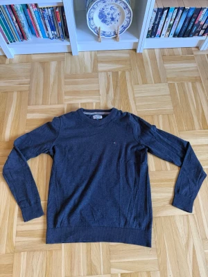 Mörkblå tröja med rund hals - Mörkblå långärmad tröja med rund halsringning och diskret liten logga på bröstet. Tröjan har ribbade muddar vid ärmslut och nederkant. Perfekt för en stilren och enkel look.