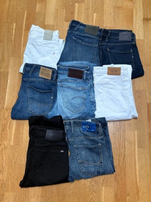 Replay & Gstar Jeans - Säljer ett gäng jeans i olika tvättar och färger – svart, vitt, mörkblått och flera nyanser av blått. Några har klassiska bakfickor med patchdetaljer och synliga sömmar. Perfekt för dig som vill variera din stil med olika fits och tvättar. Replay anbass - alla fyra är storlek 31/32! G star raw - 30/34 och 31/34! Köp alla direkt för 999kr, annars skriv om pris på vilka jeans💯