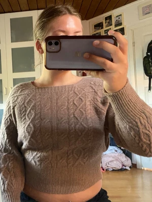 Beige tröja - Supersnygg beige tröja med kabelstickat mönster på både ärmar och framstycke. Tröjan har bred ribbad midja och muddar, samt ballongärmar som ger en trendig siluett. Perfekt för dig som vill ha något både mysigt och stilrent.