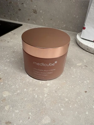 Medicube Collagen Jelly Cream - Medicube Collagen Jelly Cream i en rund burk med roséguldfärgat lock. Krämen har en geléliknande, röd formula som är framtagen för att återfukta och ge huden spänst. Perfekt för dig som vill boosta huden med kollagen. Snygg och modern förpackning. Endast testad