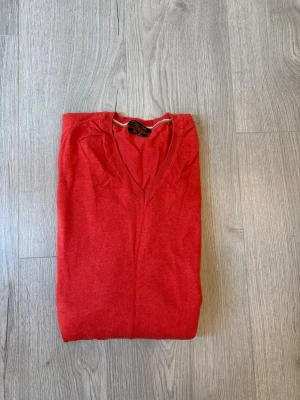Röd v ringad tröja från Massimo dutti  - Röd stickad tröja med V-ringning och bruna mockalappar på armbågarna från Massimo dutti. Tröjan är använd fåtal gånger och har inga defekter!✅ Tröjanr en XXL men jag skulle säga att den är mer en XL eller kanske till och med en L📏 skriv vid funderingar!✅Fraktar inom 24h🚚📦
