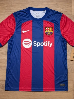 Barcelona 23/24 matchtröja - Säljer en Barcelona matchtröja från Nike i blått och rött med klubbmärke och Spotify-logga. Tröjan har korta ärmar och rund hals, tillverkad i ett lätt och ventilerande material som passar perfekt till fotboll eller träning.