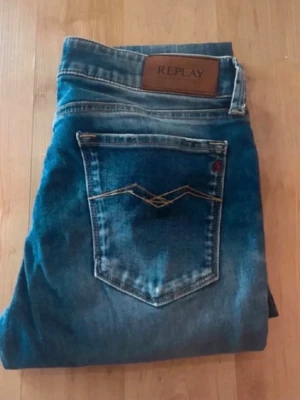 Replay jeans  - Blåa jeans från Replay med kontrastmönster, har en skinny passform. Midja 35cm, längd 103cm. Obs har ett hål på knät. JAG SKICKAR EJ FLER BILDER NÄR JAG BÄR JEANSEN! för bättre inblick i passformen rekommenderar jag att googla på modellnamnet. För storleksguide kolla måtten noggrant då jeansen alltid kan vara uppsydda heller krympta och jag ej tar emot returer :) (r26)