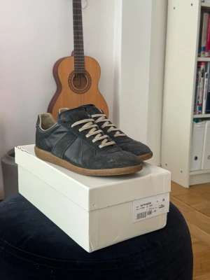 Maison Margiela gats blåa  - Maison Margiela sneakers i blått läder och mocka med beige snören och klassisk gummisula. Snygg retrostil med låg profil och diskreta detaljer. Perfekta för dig som gillar minimalistisk design och streetwear-vibe. Box medföljer samt dustbags, storlek 40. Mitt pris är 2299, skriv dm för frågor.