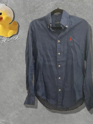 Blå linneskjorta från Ralph Lauren - Säljer denna blåa linneskjorta från ralph lauren i storlek XS. Passar folk runt 164-174. Skriv vid funderingar!