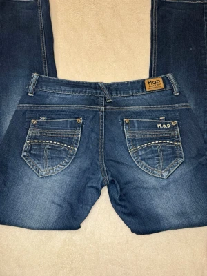 Lågmidjade bootcut jeans från M.O.D - Säljer ett par skit snygga lågmidjade bootcut jeans från M.O.D/Miracle of denim! Lågmidjade och sitter skit snyggt på! Kan alltid skicka mått privat!💕