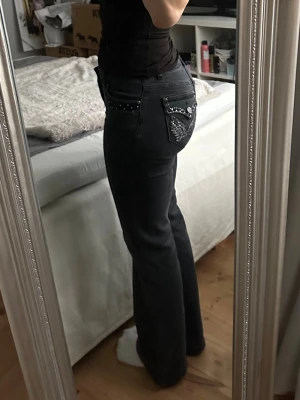 BootcutJeans Madlady - Snygga svarta bootcut-jeans med dekorativa detaljer på bakfickorna. Jeansen har en smickrande passform, klassiska bak- och sidofickor, hällor för skärp samt gylf med dragkedja. storlek 34/short, passar mig perfekt som är 161cm. Fint skick! Knappast använda. Perfekta att styla både till vardags och fest – en tidlös modell med det lilla extra. 🖤
