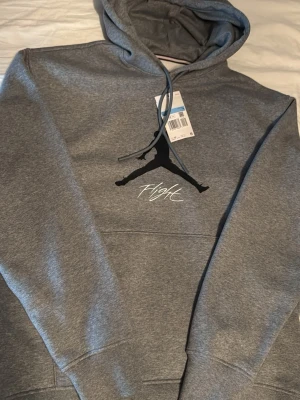 Jordan hoodie - Säljer en Jordan Flight hoodie i grått. Använd få gånger och i väldigt fint skick. Köpt för ca 900 kr och prislappen finns kvar. Inga fläckar eller skador. Pris: 650 (kan diskutera pris)