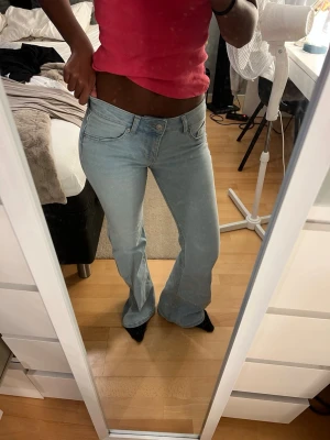 Ljusblå bootcut jeans - Säljer ett par ljusblå bootcut jeans från hm, midrise och aldrig använt🥰( stora i storleken )