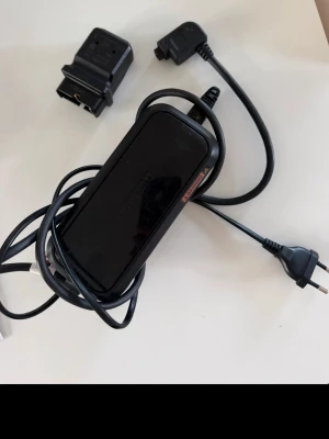 shimano steps ec e8004 batteri laddare + adapter  - EC-E8004-1-laddaren är till för att ladda ditt SHIMANO STEPS utan att ta ut det från din elcykel och har snabba laddningstider och en liten kontakt. Den kan även ladda batteriet direkt genom användning av en adapter. Lättviktig och bärbar batteriladdareSamma kompakta storlek och vikt som EC-E6002SnabbladdningSnabbladda från halvfullt till 80 % på 1 timme. Adapter medföljer.