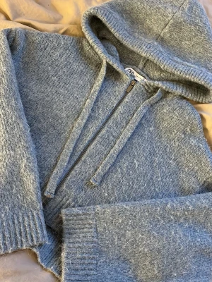 Blå stickad hoodie från Zara - En grå/blå stickad zip up från Zara i strl XS/S, den har små slitsar på sidorna