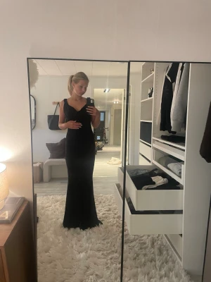 Svart lång klänning  - Intressekoll!!!! En fin svart lång klänning med en djup rygg från design by si jättefin men kommer inte till andvändning just nu. Köpt för 800 kr
